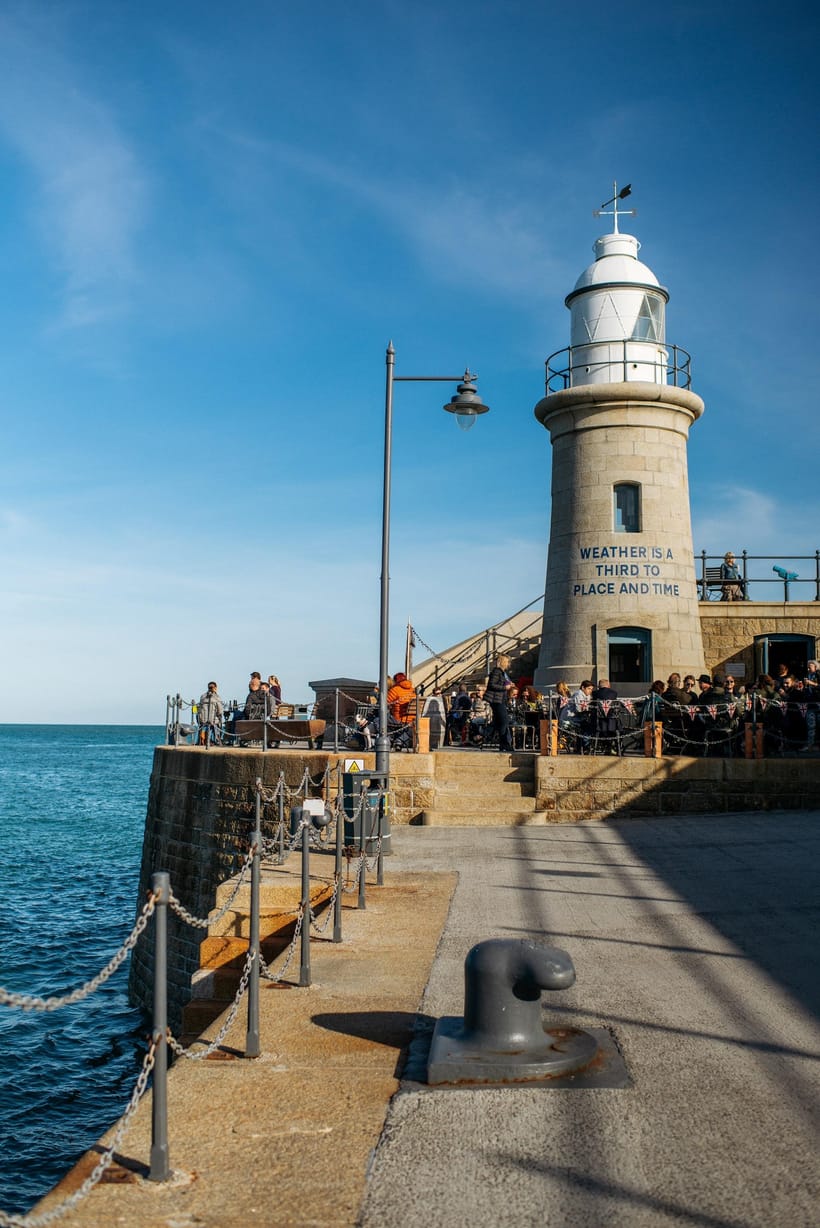 Folkestone harbour arm lighthouse in golden light — the journey's end